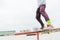 A close-up of a teenager`s leg of a skateboarder glides on a skateboard along the railing in the skatepark. The concept