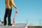 Close-up Teenager standing in a yellow hoodie holding a hand skateboard on the background urban slum