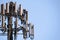 Close up of telecommunications cell phone tower with wireless communication antennas; blue sky background and copy space on the