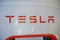 Close-up of Tesla inscription at the station for refueling electric vehicles. The company produces modern eco-friendly