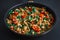 Close up of Texas Caviar: delicious one pan fried vegetable mix with tofu, low fat, vegetarian, on a black background, top view.