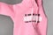 Close-up on the text of the inscription on the pink jersey overalls, sweater, sweatshirt, t-shirt, fabric, fabric