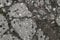 Close-up texture of gray granular granite with small stones with large cracks.