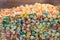 Close-up texture of multi-colored popcorn in a glass movie theater container. Popcorn with a variety of colors and