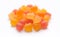 Close-up texture of orange and yellow multivitamin gummies in the form of bears on white background.