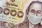 Close up of Thai banknote, Thai bath with the image of King Bhumibol Adulyadej Worried and Concerned Expression Wearing Medical