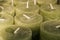 Close-up of thick green wax candles in shop. Warehouse of handmade scented candles