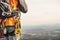 Close-up of a thigh climber with equipment on a belt, stands on a rock