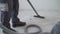 Close-up of thoroughly vacuums the concrete floor. A worker vacuums the floor from industrial concrete dust and cement mud during