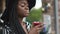 Close-up of and thoughtful african american lady in black hat and striped vogue dress with cool cocktail in bar