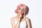 Close-up of thoughtful attractive girl with pink anime wig and bright makeup, looking at upper left corner banner and