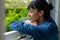 Close-up of thoughtful caucasian young woman looking through window