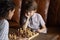 Close up thoughtful little boy playing chess with mother