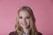 Close up Thoughtful Pretty blondy Girl Looking Up with a Smile, Isolated on Pink Background