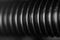 A close-up of the thread of a black bolt with whitening ribs of a spare part in an auto service as a background for publication in