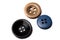 Close up of three buttons. Black, gold, blue in color