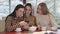 Close-up of three caucasian female friends looking at smartphone screen in restaurant and talking. Young women gossiping