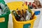 Close up of three colorful green, yellow and white recycle garbage bins full of rubbish isolated on white background