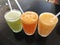 Close-up of three glasses of freshly squeezed juice with tubes. Delicious, nutritious and healthy drinks