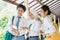 close up of three high school students look together and point to the mobile phone screen