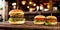 Close-up of three juicy cheeseburgers on a wooden table on a kitchen board against a background of a blurred rustic