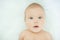 Close-up of three months old baby girl with blue eyes. Newborn child, little adorable smiling girl looking at camera