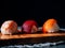 close-up of three pieces of sushi, dark background