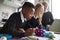 Close up of three primary school children working together with toy construction blocks in a classroom, low angle, side view