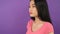 Close-up three quarter portrait of young asian woman on isolated purple background 4K