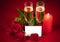 Close-up of three red roses, two glasses of champagne and a lit red candle on a red background in honor of Valentine`s