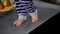 Close-up tiny little feet walking on tabletop in kitchen at home. Live camera follows steps of unrecognizable toddler