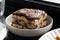 Close-up of tiramisu on a white plate under natural daylight