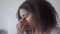 Close-up of tired beautiful African American woman rubbing eyes working at home office indoors. Headshot portrait of