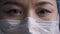 Close up of tired doctor eyes. Woman wearing protective mask looking at camera. Medic feels stress after a long overtime