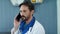 Close up tired male doctor talking phone in office. Doctor listening patient