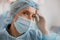 Close up of tired surgeon in mask standing in operating room after major surgery