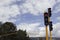 Close up to a bicycle and vehicular traffic lights with yellow base, mountains and blue sky at background