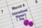 A close up to a Calendar on March 8 with the text: International Women`s Day with a pink and woman`s symbols.