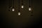 Close up to a group of hanging classic Tungsten Lamp in the dark area with rope