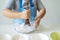 Close up to the hand of an Asian girl learning candy, she is pouring the ingredients together.