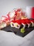 Close up to Japanese sushi roll with tuna, avocado and flying fish roe on top. rose petals and candles near served dish. Sushi