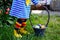 Close-up of of toddler girl with colorful stockings and shoes and basket with colored eggs. Child having fun with