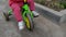 Close-up of toddler girl who rides a tricycle down the street