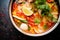 close-up of tom yum goong with vibrant tomato pieces