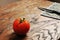 Close-up of a tomato and black knife with napkin on the wooden table