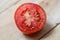 Close up of Tomato slice on wooden background - macro tomatoes