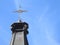 Close-up of the top of a church tower with a cross