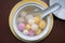 Close up top side view of red, orange and white tangyuan tang yuan, glutinous rice dumpling balls .in white bowl