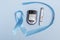 Close-up top view of 14 November World Diabetes Day concept. Blue tape with blood drops and a glucometer on a blue background.