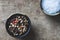 Close up and top view of coarse salt and allspice in ceramic containers on old rustic table